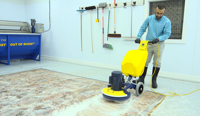 professional worker cleaning rug
