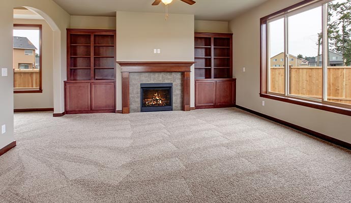 a vacant living room featuring a clean, beige-colored carpet