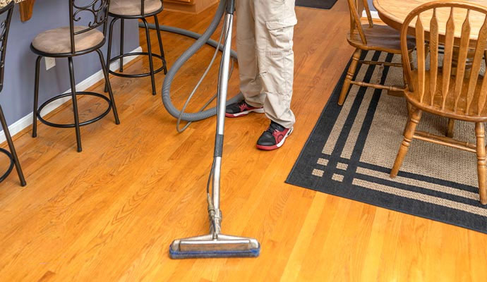 Professional worker cleaning hardwood floor