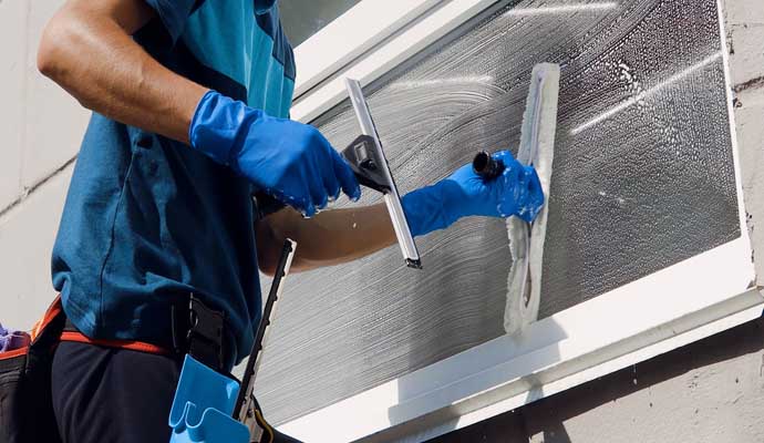 a person cleaning a window using a squeegee