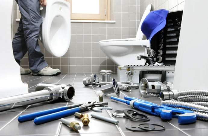 Plumber inspecting a toilet with professional tools.