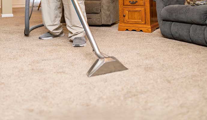 A person is cleaning a carpet with equipment