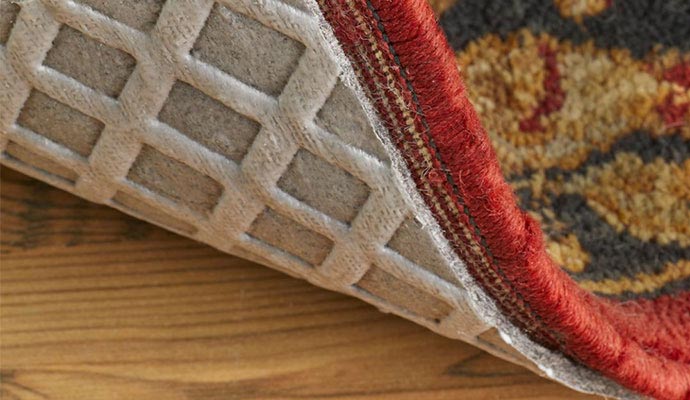 Close-up view of a rug with a non-slip pad on a wooden floor