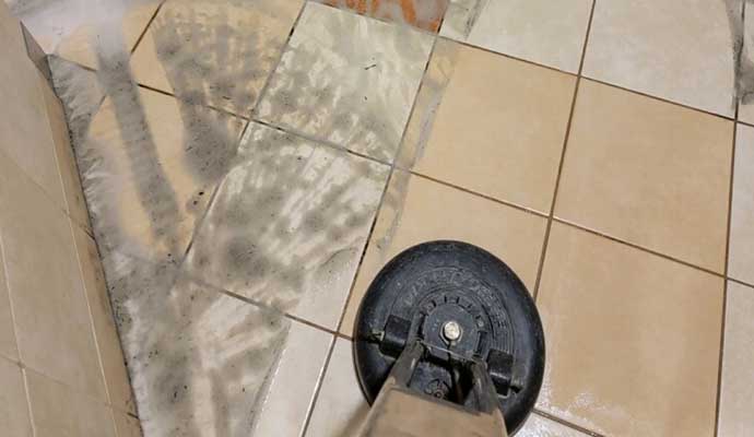 A cleaning machine is being used to clean a tiled floor